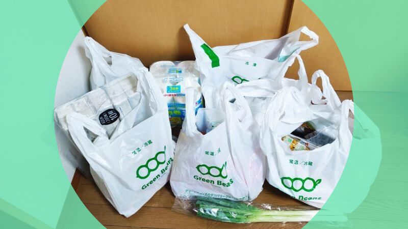 グリーンビーンズの配送用ビニール袋に小分けされた商品の梱包状態。生鮮食品や日用品が種類ごとに整理されており、配送中に中身が崩れたり汚れたりしないよう丁寧にパッキングされている様子。