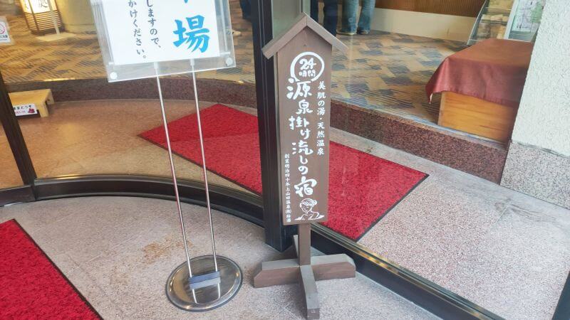 源泉かけ流しの宿が書かれた看板