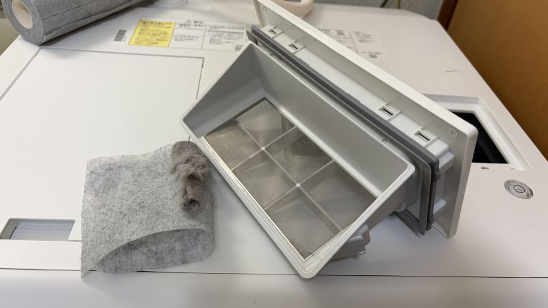 乾燥フィルターに溜まったホコリを、カットした掃除シートでサッと絡め取っている様子。