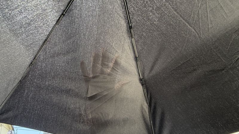 今日の強い光の下での検証。傘の内側に手を当てるとシルエットが透けて見え、可視光線が透過していることが分かる。