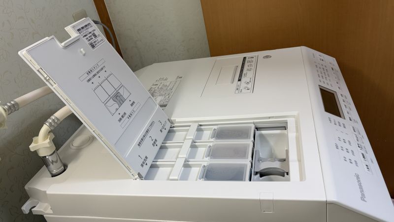パナソニックNA-LX127の3つの自動投入タンク（洗剤・柔軟剤・おしゃれ着洗剤）を開けた様子。日々の計量の手間を省き、「名もなき家事」を大幅に削減してくれる。